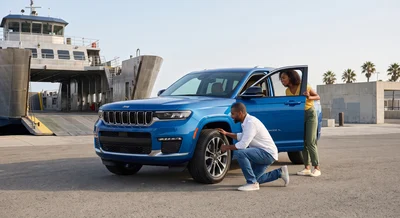 Couple examining modern blue SUV before boarding ferry, checking rental car for travel in Florida.