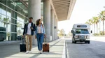White car rental shuttle bus picking up passengers with luggage outside LAX Terminal 7 in Los Angeles