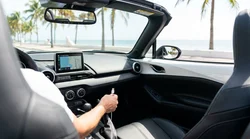 USB cable connected to a dashboard screen displaying Apple CarPlay in a Miami car rental