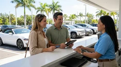 White convertible car rental driving along a sunny coastal road with palm trees in Florida