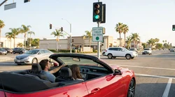 Driver in a car rental waiting to turn left at a green traffic light in California