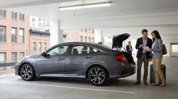 Person handing a credit card to a staff member at a car hire desk in New York