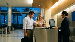 Traveler with a suitcase approaching an airport car rental desk in Orlando at night