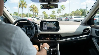 Driver checking the dashboard reversing camera screen of a car hire in Orlando