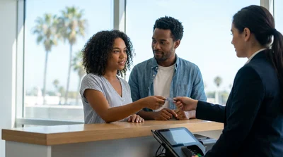 Customer handing a credit card to an agent at a Los Angeles car hire counter