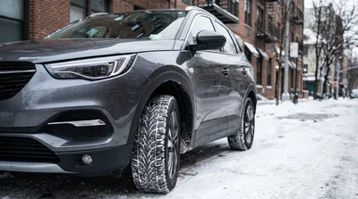 A car rental with winter tyres parked on a snow-covered street in New York