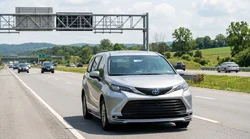 Silver car rental driving under an overhead toll camera on the Pennsylvania Turnpike