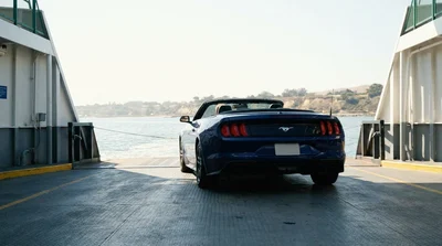 White car rental parked on the open deck of a passenger ferry crossing the water in sunny California
