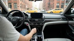 Hand plugging a smartphone cable into the dashboard USB charging port of a car rental in New York
