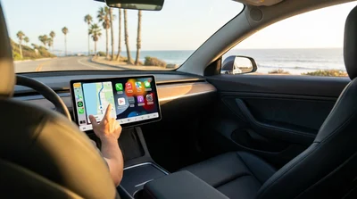 Close-up of a dashboard touchscreen displaying a map inside a car rental on a sunny California road
