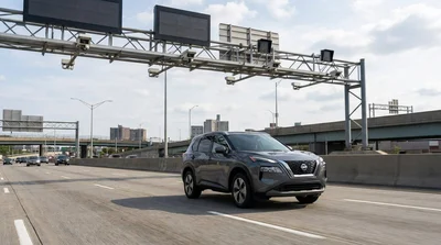 White car rental passing under an electronic toll gantry on a New York bridge