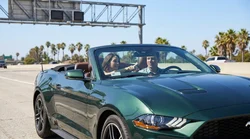 Modern car rental driving on a sunny Los Angeles highway with palm trees in the background