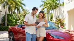 White convertible car rental parked near a sunny beach and tall palm trees in Miami