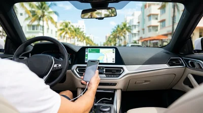 Driver plugging a smartphone into a dashboard USB port inside a car rental in Miami