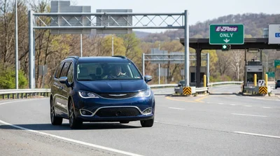 A driver in a car rental approaching an electronic highway toll booth in Pennsylvania