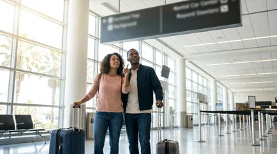 Customer approaching the Hola car rental desk inside the Orlando airport terminal