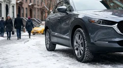 Silver car rental parked on a snowy New York street with visible winter tyres