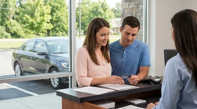 Close-up of a customer handing a credit card to an agent at a car rental desk in Pennsylvania