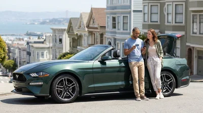 Customer handing a credit card to an agent at a car rental desk in San Francisco