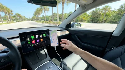 Smartphone displaying Android Auto connected by USB-C cable to the dashboard of a Florida car rental