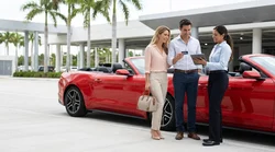 Person handing a credit card to a customer service agent at a car hire desk in Miami