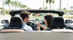Driver using a smartphone navigation map mounted on the dashboard of a car rental on a sunny Orlando highway