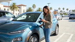 Electric vehicle plugged into a charging station at a sunny California car hire lot