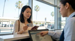 Person driving a car rental along a sunny coastal highway in California with ocean views