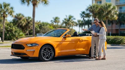 White convertible car rental driving on a scenic highway lined with palm trees in Florida