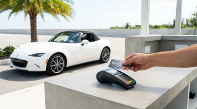 Customer tapping a credit card on a contactless reader at a Florida car hire counter
