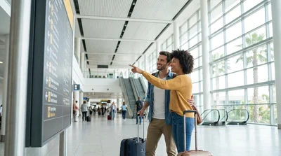 Passengers with luggage walking under a car rental directional sign at Orlando Airport