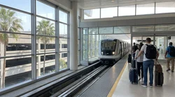 People with luggage boarding the MIA Mover train heading to the Miami car rental center