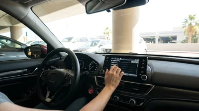 Person tapping the dashboard touchscreen inside a Las Vegas car rental