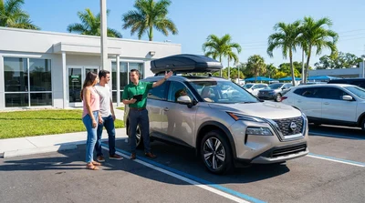 Silver SUV parked near a Florida beach with luggage strapped to the car rental roof rack