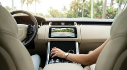 Reversing camera screen on the dashboard of a car rental parked under palm trees in Florida