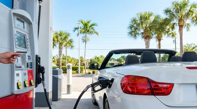 Close up of a person pumping fuel into a car hire at a Florida gas station