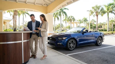 Close up of hands exchanging keys and a credit card at a Florida car hire counter