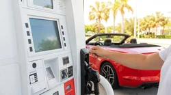 Driver pumping gas into a car rental at a Florida gas station