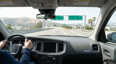 A car hire driving on a highway towards the downtown San Francisco skyline on a sunny day