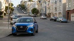Compact car rental parked on a steep hill street with Victorian houses in San Francisco