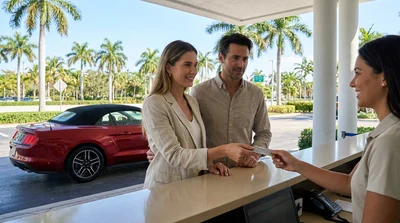 Customer handing a credit card to an agent at a car rental counter in Miami