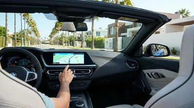 Built-in navigation screen on a car rental dashboard with Los Angeles streets visible through the windshield