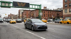 A modern car rental stuck in heavy downtown traffic on a busy street in New York
