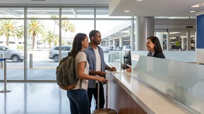 Traveler handing documents to a clerk at a San Francisco car rental desk