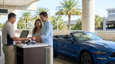 Customer handing a credit card to an agent at an Orlando car hire desk