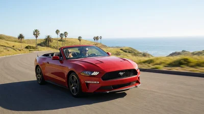 White car rental driving on a scenic coastal highway next to the ocean in California