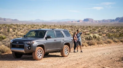 White 4WD car rental driving along a rugged dirt road in the desert near Las Vegas