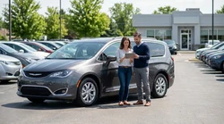 A person reviewing a Pennsylvania car rental agreement on the hood of a white sedan