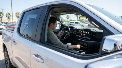 Driver setting up Apple CarPlay on the dashboard screen of a car rental in Texas