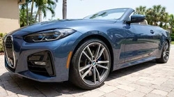 Close-up of a scratched alloy wheel on a car rental parked on a sunny Florida street